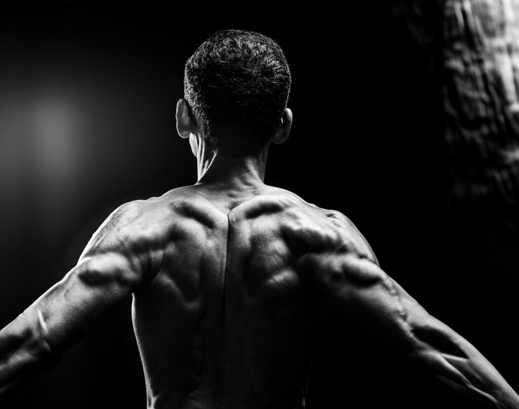 Dynamic black and white portrait highlighting muscular physique and body definition.