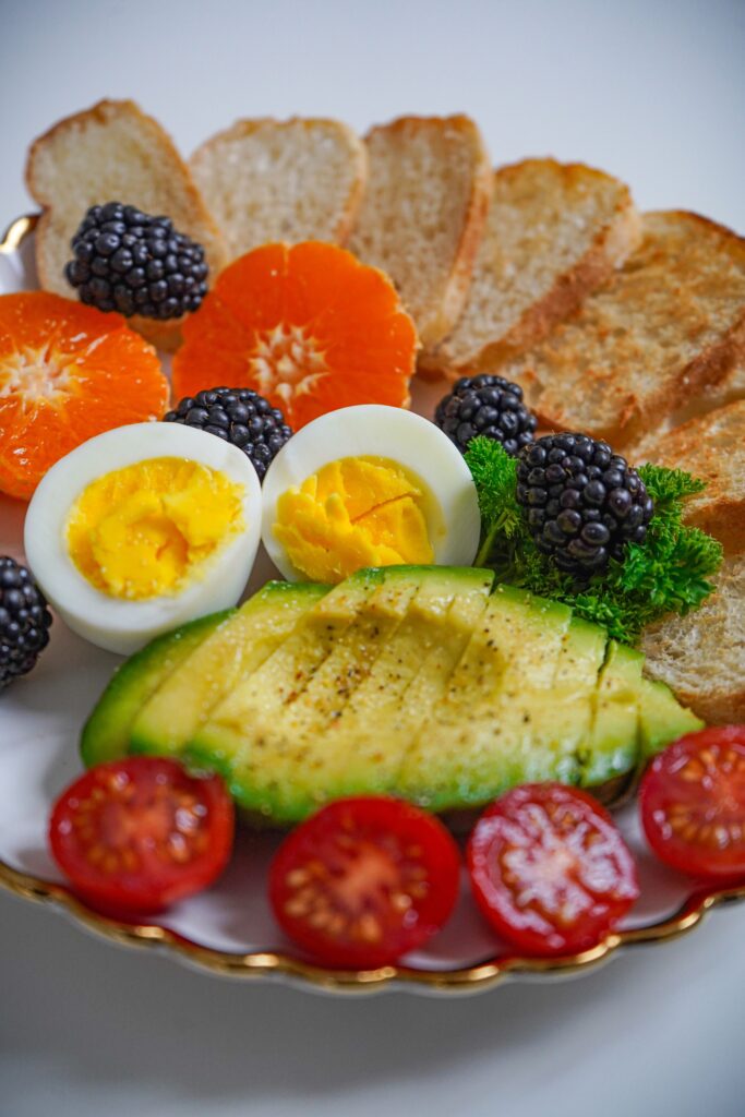 A vibrant plate featuring avocado, egg, tomatoes, and berries, ideal for healthy eating.