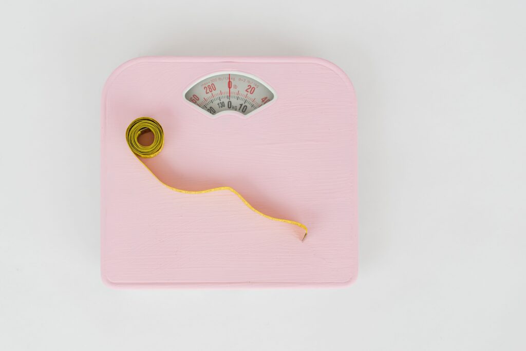 Hábitos Saludables para Perder Peso: 10 Cambios de Estilo de Vida que Funcionan Top view of floor scales for weight control and measuring tape for controlling body shapes on white background