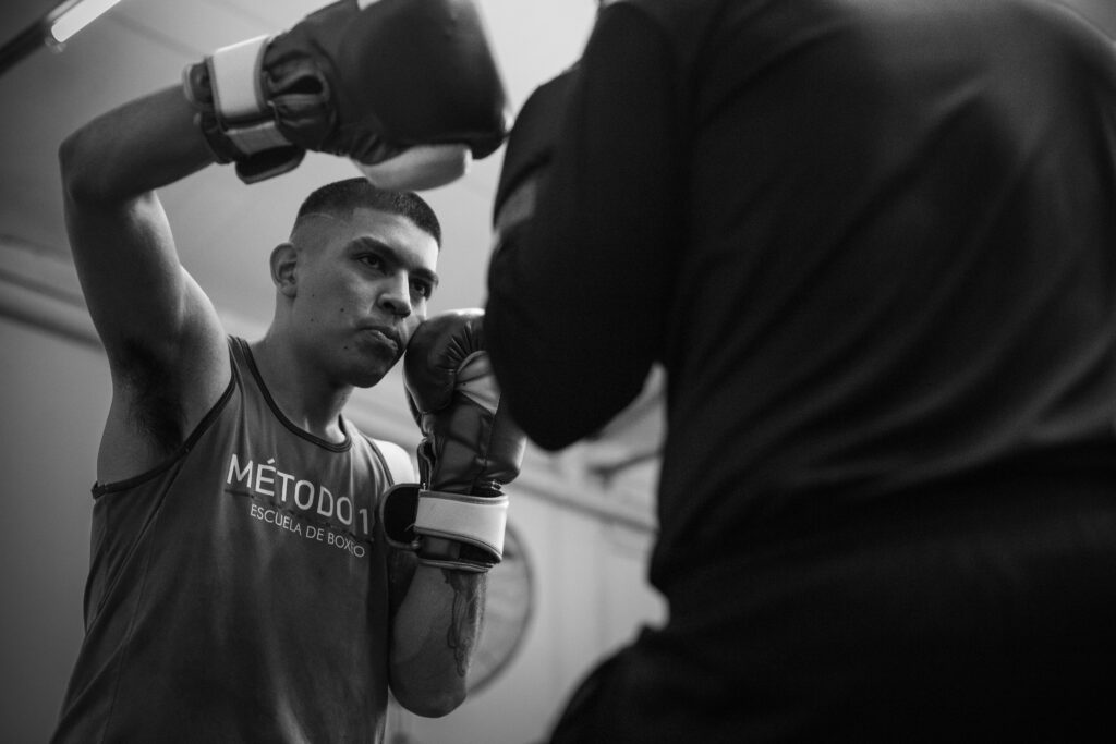 10 Consejos para Empezar en el Boxeo desde Cero en 2026 Intense boxing training session in a Buenos Aires gym, showcasing focus and technique.