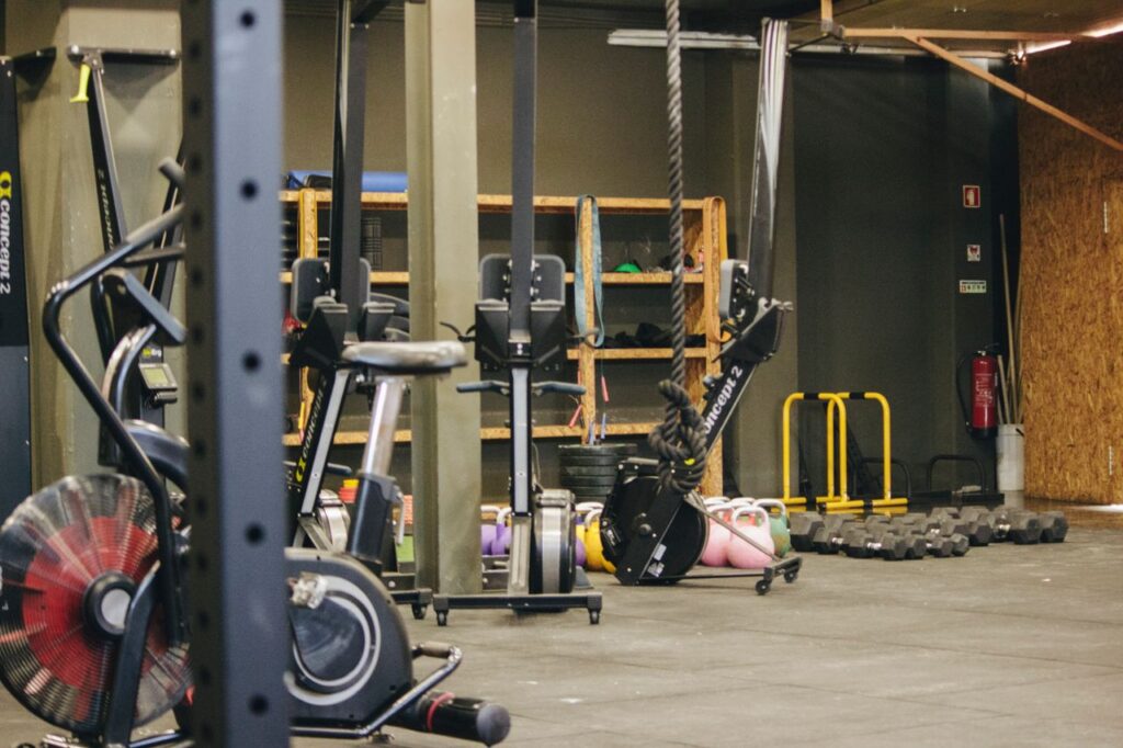 Cardio vs Pesas: Qué Elegir Según tu Objetivo (Perder Grasa, Ganar Músculo o Resistencia) An indoor gym with various exercise equipment and weights ready for workout.
