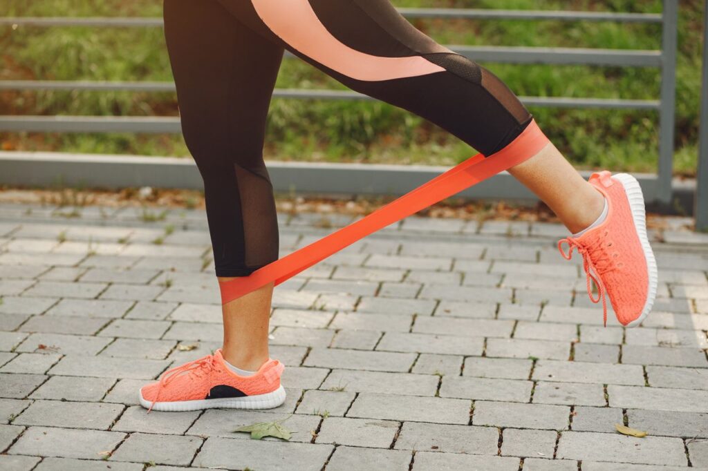 Mejores Bandas Elásticas de Resistencia 2026: Guía Completa y Top 5 en Amazon Close-up of a woman exercising with a resistance band in a park.